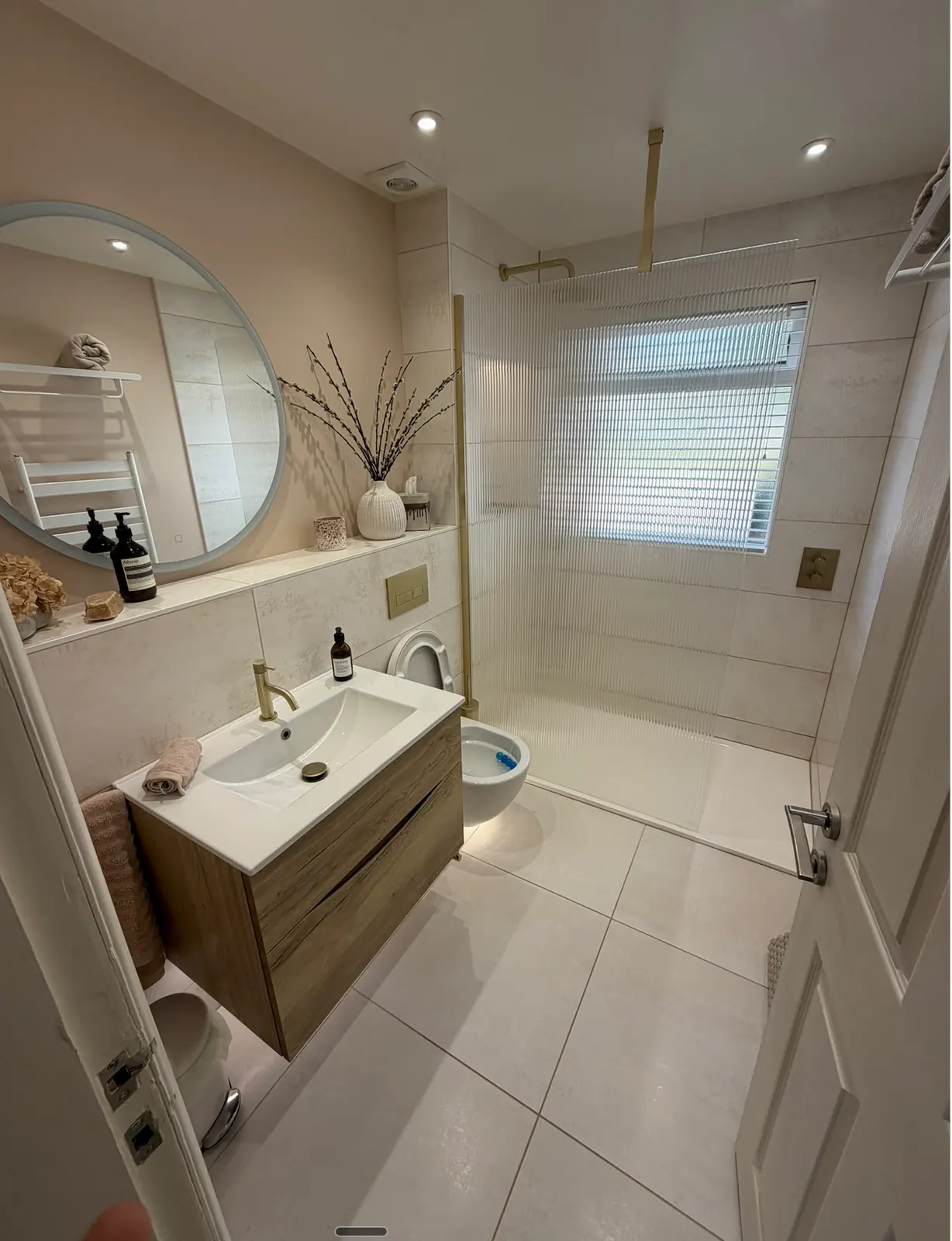 Shower room with recessed ceiling lights, a round mirror and a vanity unit