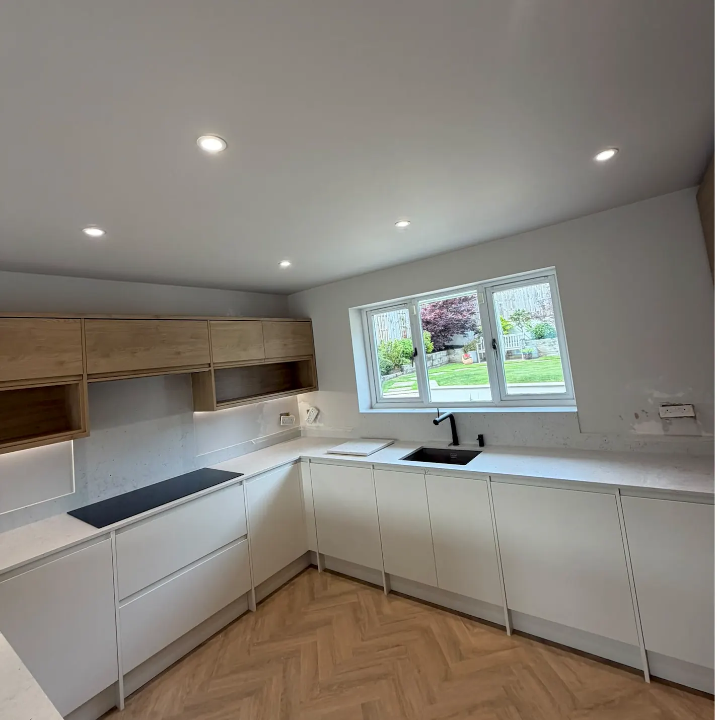 White kitchen with wood-effect wall cabinets and recessed ceiling lights