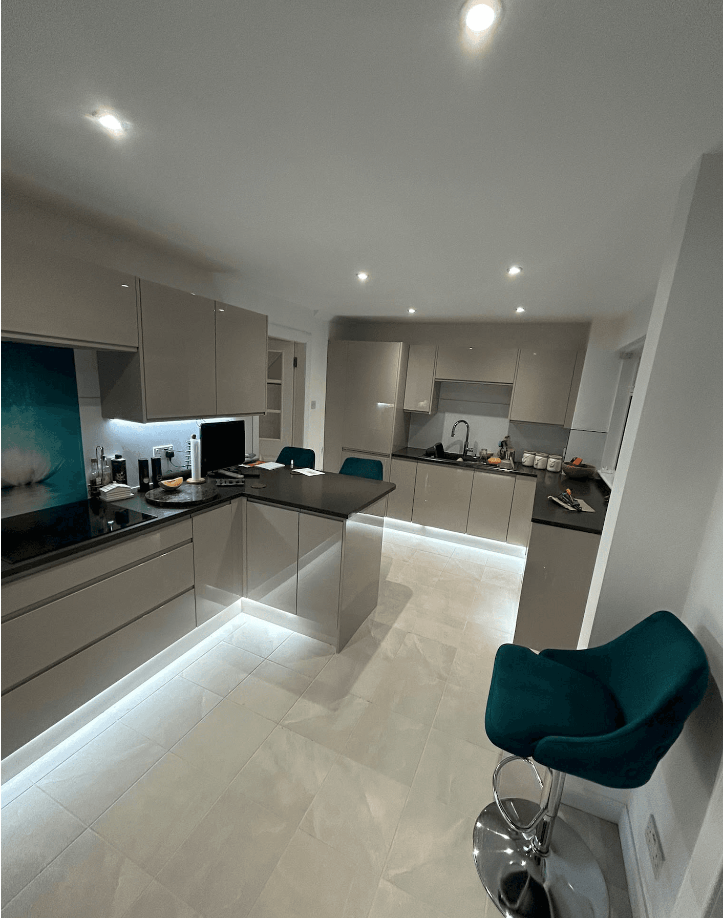 Kitchen with recessed ceiling lights, under-cabinet lighting and illuminated plinths