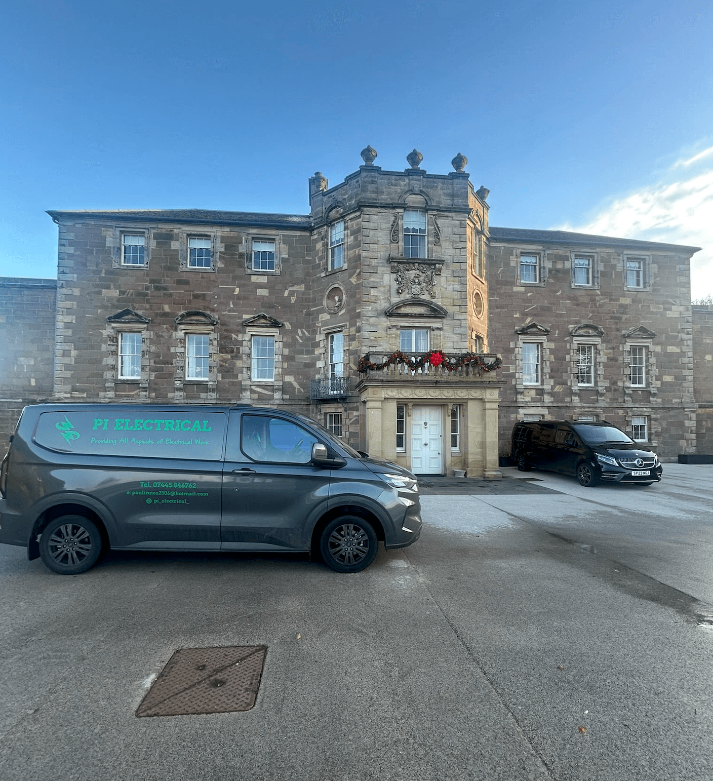 PI Electrical van parked outside a large stone building