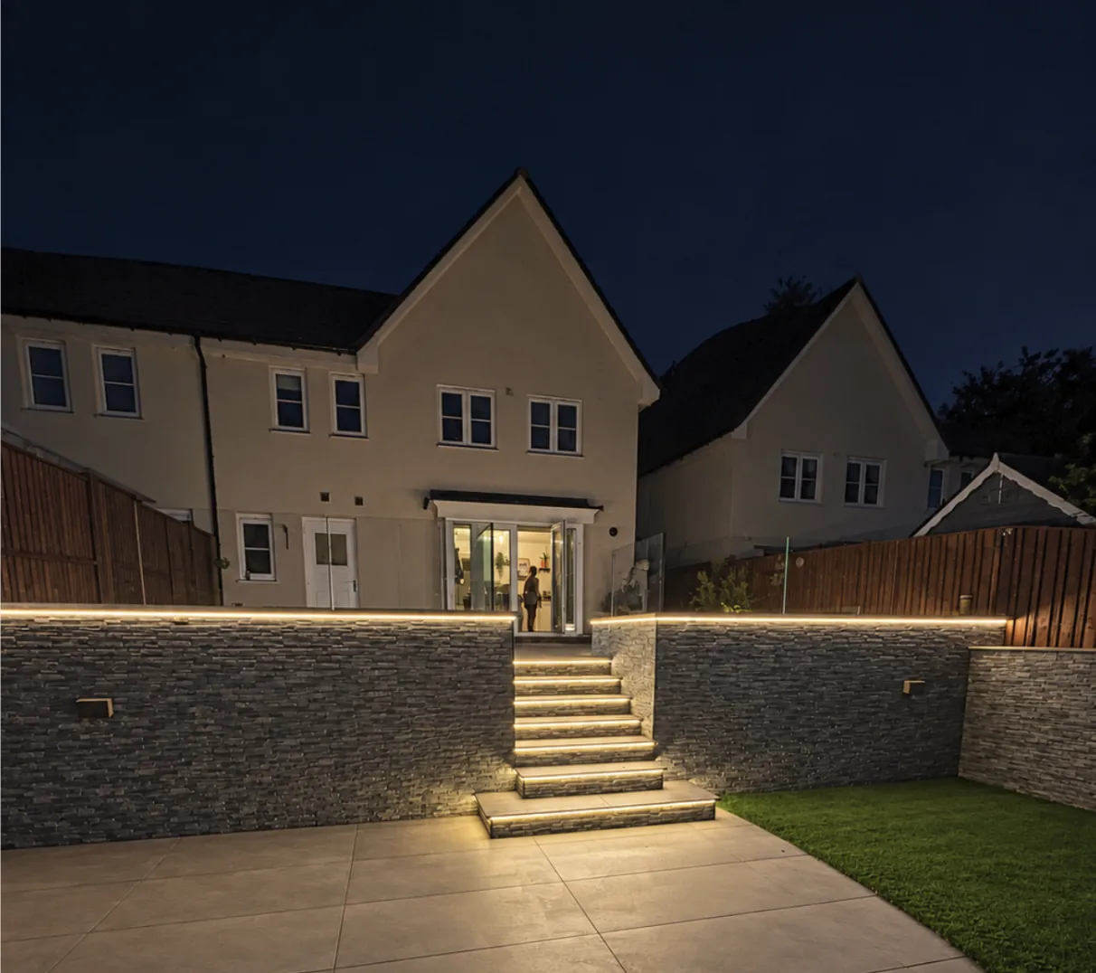 Garden steps and stone walls illuminated by LED strip lighting at night