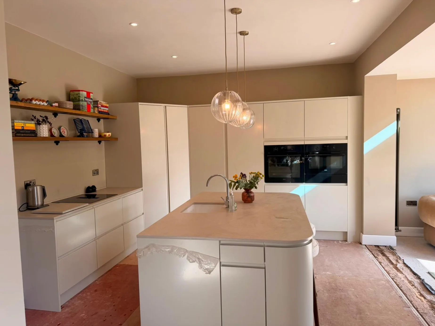 Glass pendant lights above a kitchen island with recessed ceiling lights