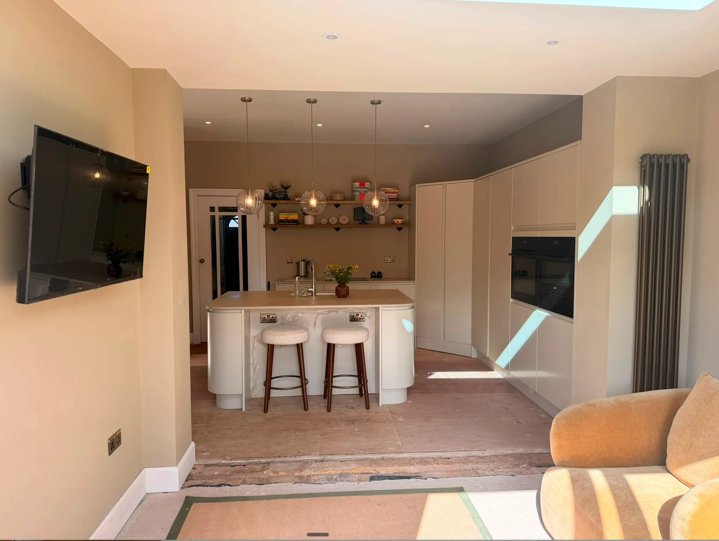 Three glass pendant lights above a kitchen breakfast bar