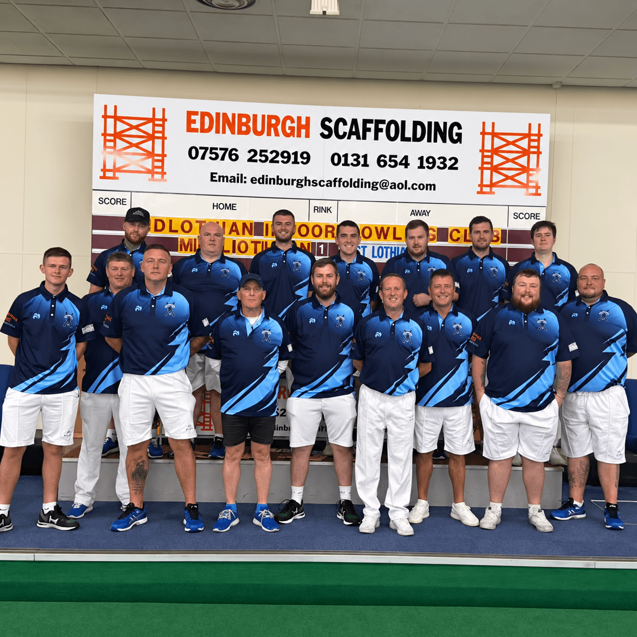 Midlothian Indoor Bowling Club team posing by the scoreboard in their sponsored strips