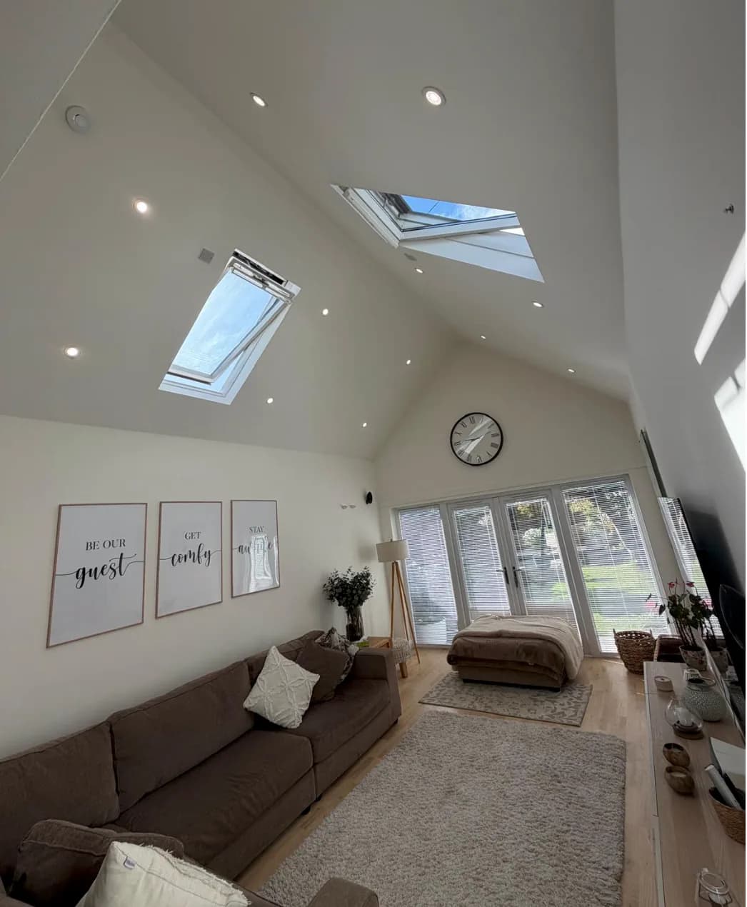 Recessed downlights in a vaulted living room ceiling with roof windows
